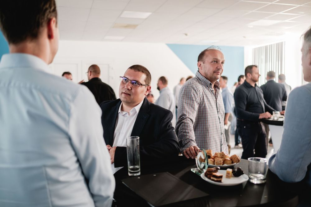 Business professionals networking and enjoying refreshments at corporate event.