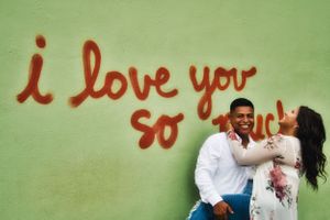 engaged couple posing in front of a mural