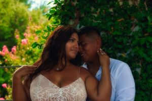 engaged couple holding each other in front of foliage