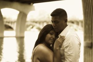couple holding each other in sepia tones in front of a lake