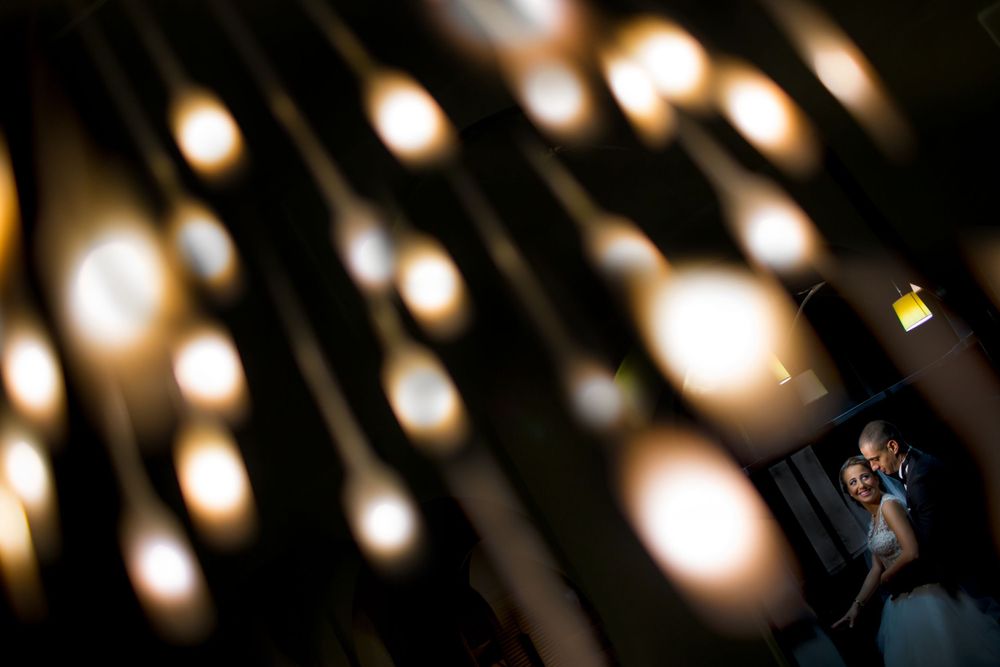 Artistic wedding portrait with dramatic bokeh lighting pattern creating unique shadows.