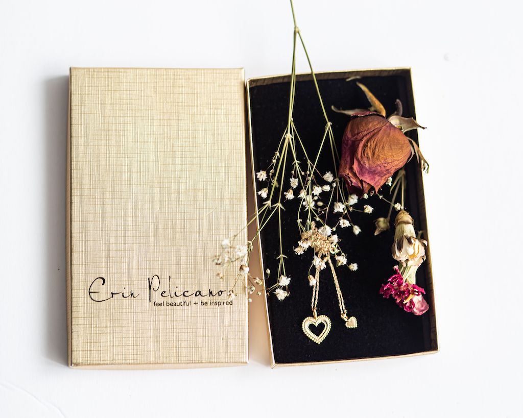 Layflat of Erin Pelicano's fine jewelry, decorated with roses and other flowers