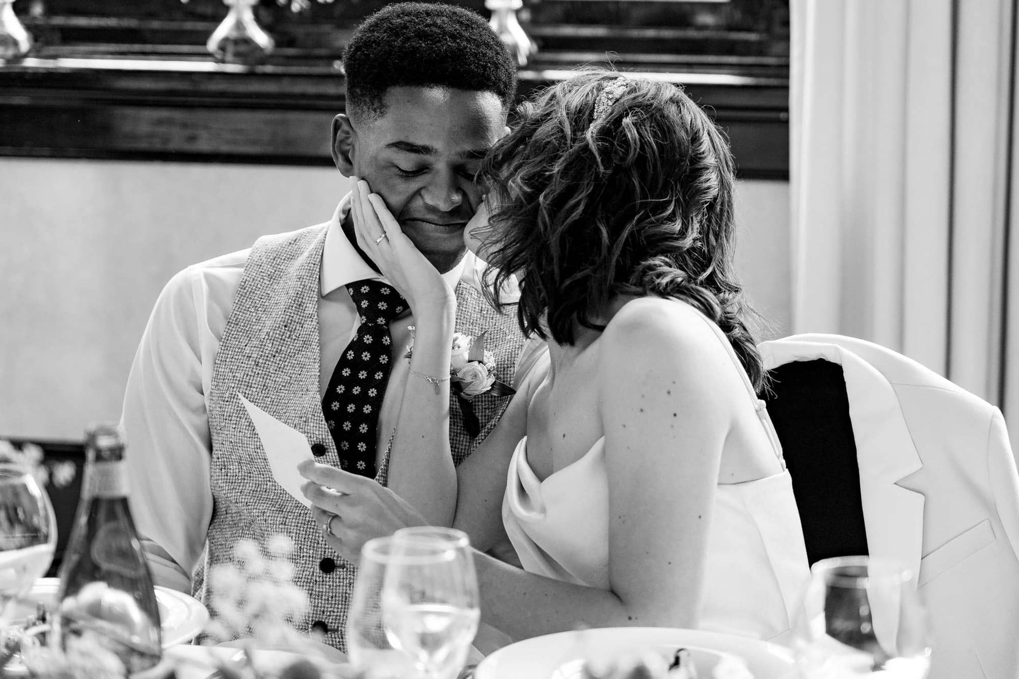 Bride and groom share an intimate kiss during the wedding dinner at a restaurant in The Hague.
