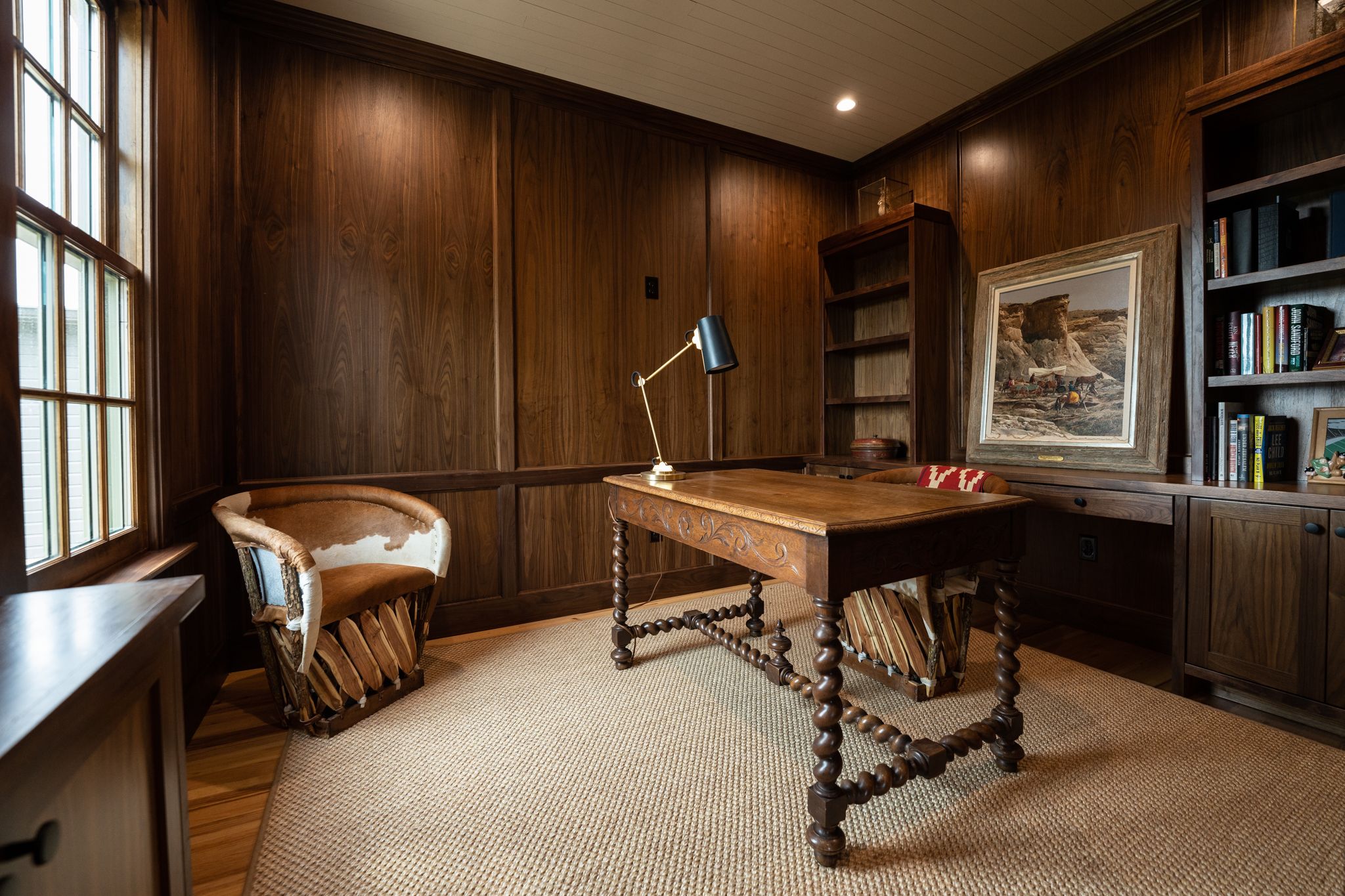A luxurious wood-paneled home library with built-in bookshelves, leather furniture, and warm lighting creates a cozy atmosphere.