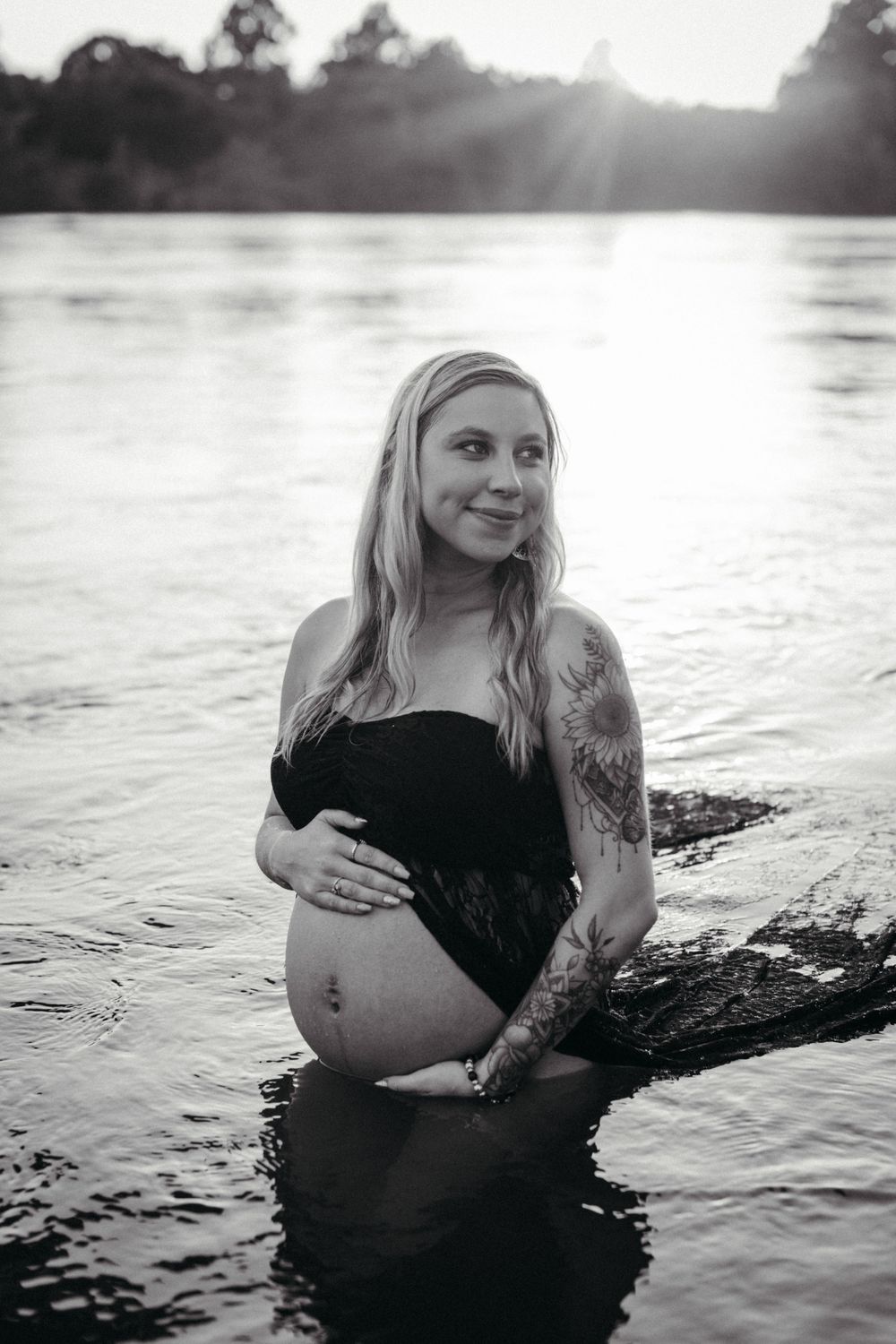 Black and white maternity photos captured in lake water during sunsetat Seven Islands State Birding Park.