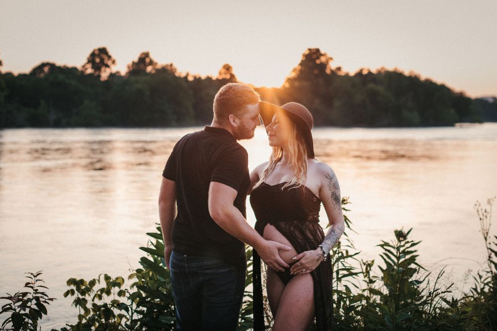 Sunset maternity photography session by a serene lake at Seven Islands State Birding Park.