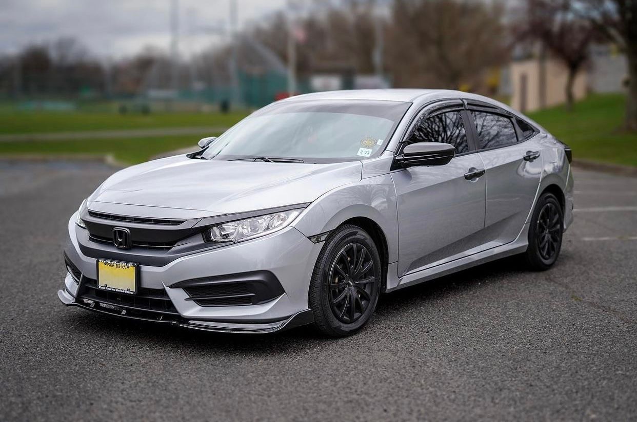 Modified silver Honda Civic sedan with custom wheels parked on a street.