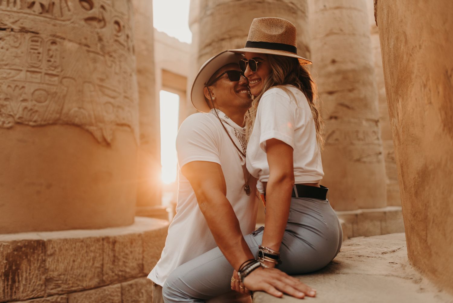 A tender moment shared between two people among ancient Egyptian temple columns.