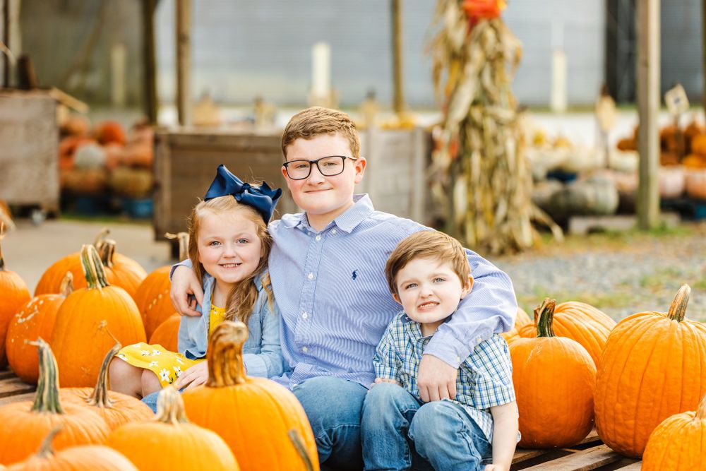 Autumn scene with bright orange pumpkins arranged on a rustic porch display.