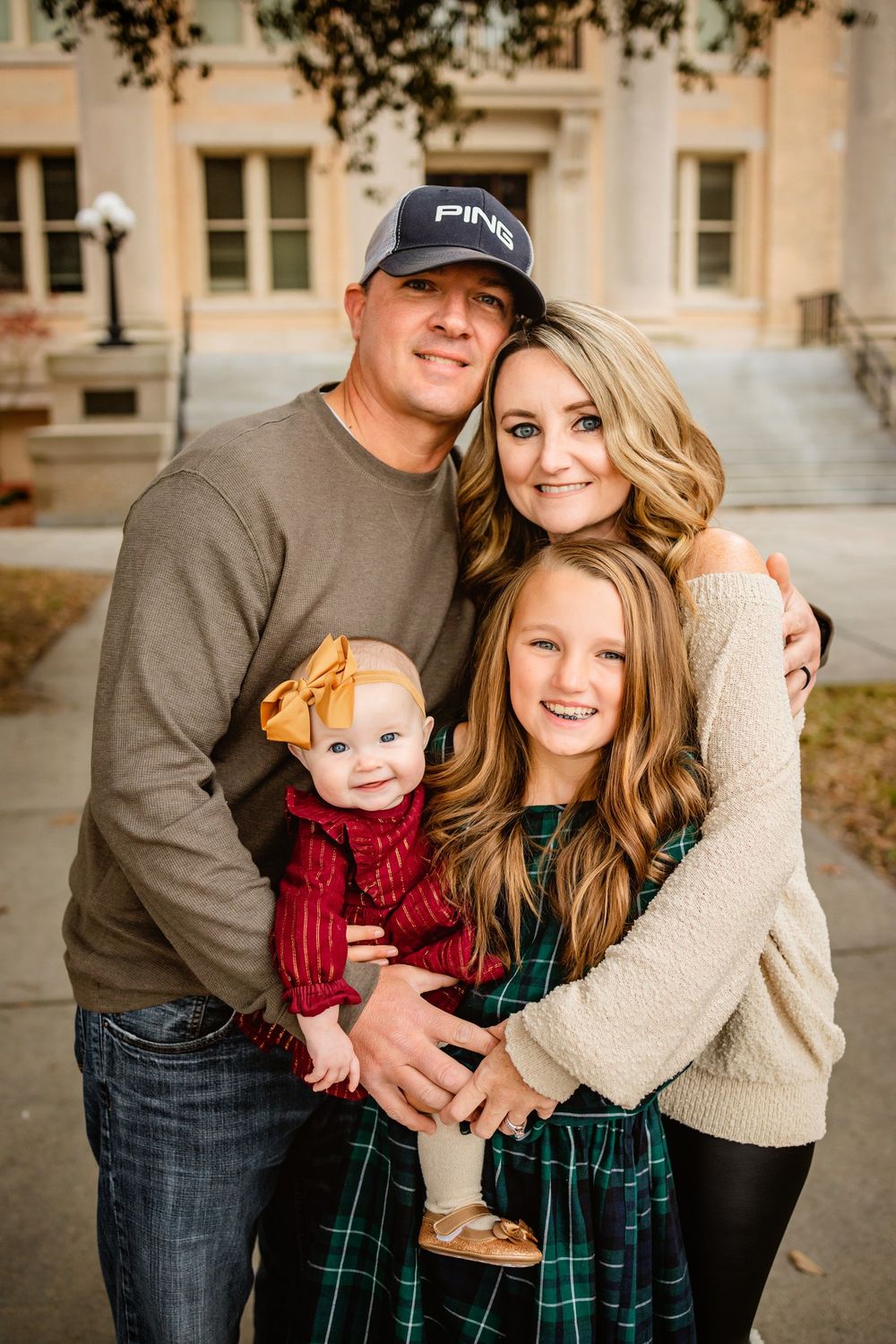 Family portrait with coordinating outfits in green and neutral tones.