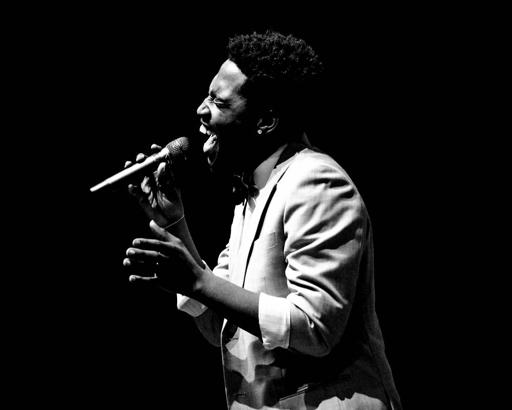 Dramatic black and white performance photos of singer on stage in spotlight.