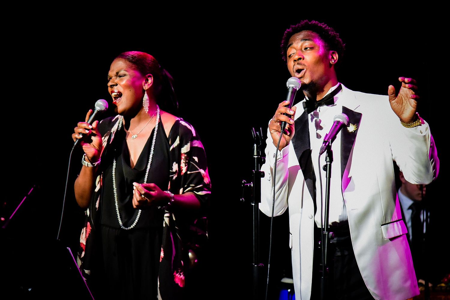 Concert performance with dramatic pink and purple stage lighting effects.
