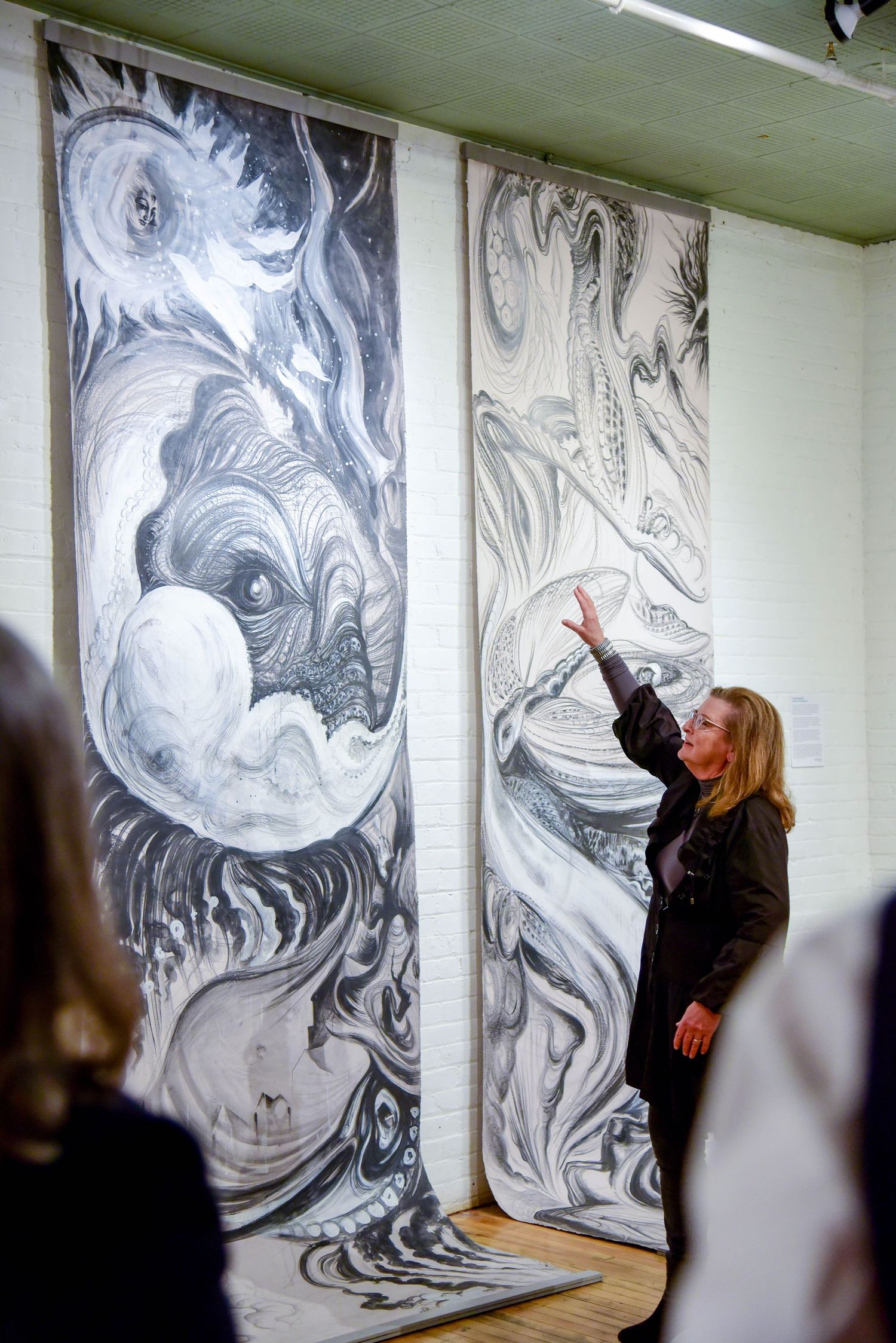 Large black and white abstract mural artwork displayed on wall with dramatic swirling patterns and ethereal forms.