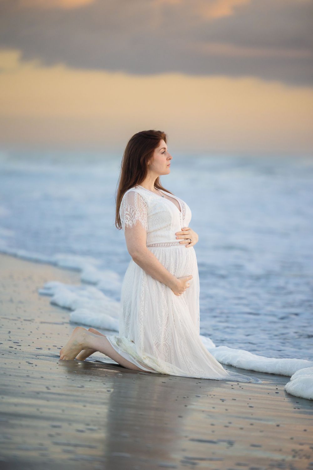 Ethereal beach photography with woman in white dress at sunset.