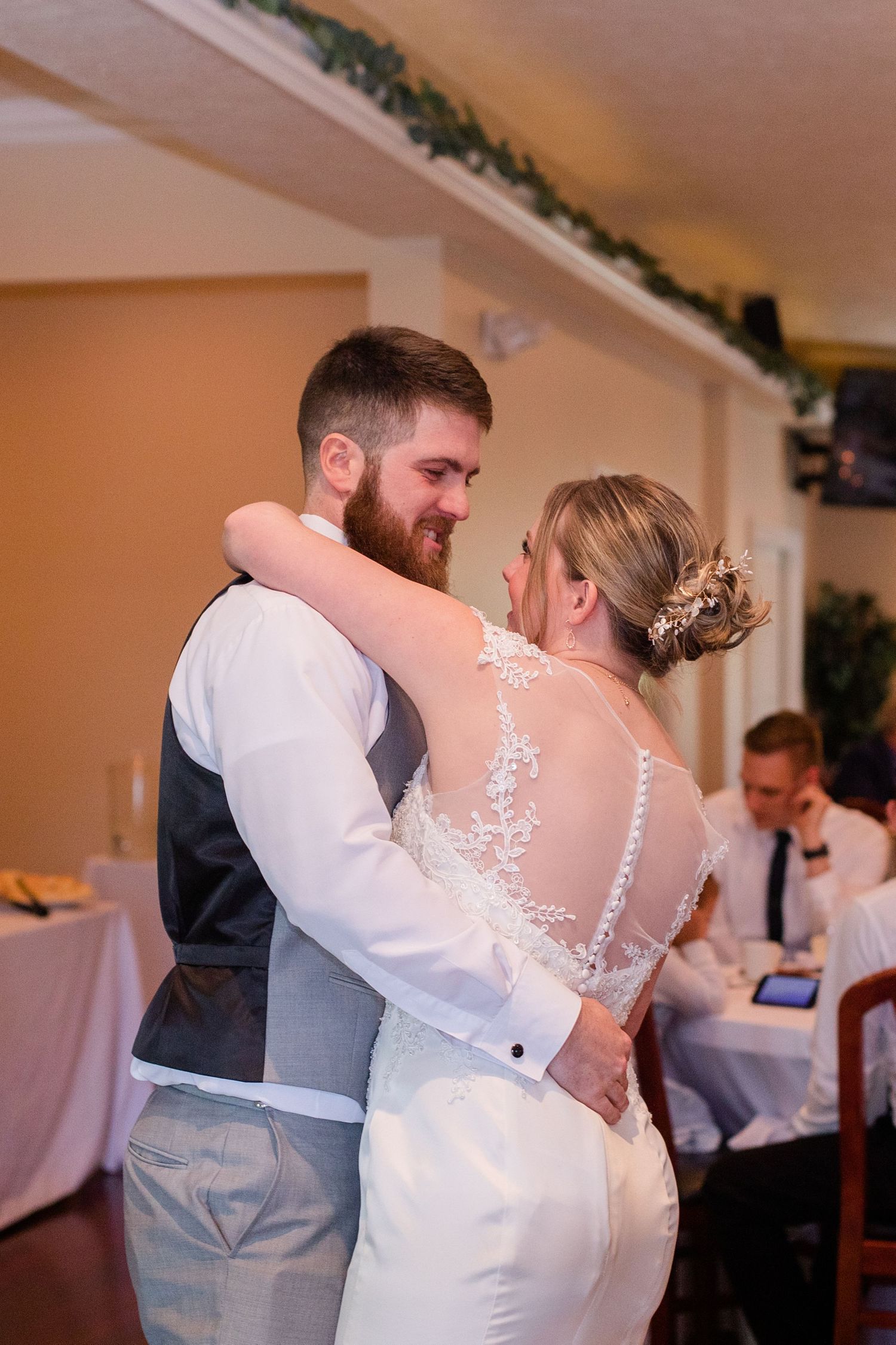 Dancing couple shares an intimate moment during their first dance at a wedding reception.