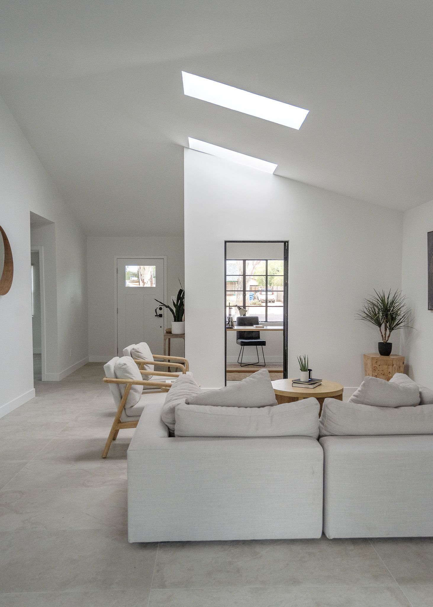 Minimalist white living room with skylight and contemporary sectional sofa.
