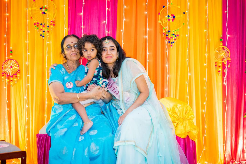 Family celebration moment against colorful draped backdrop with string lights.