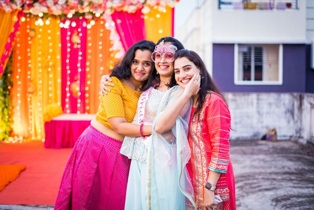 Colorful backdrop with orange and pink string lights creates festive ambiance at celebration.
