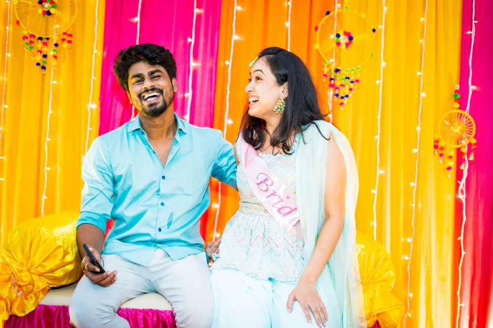 Celebration moment captured against vibrant yellow and orange draped background.