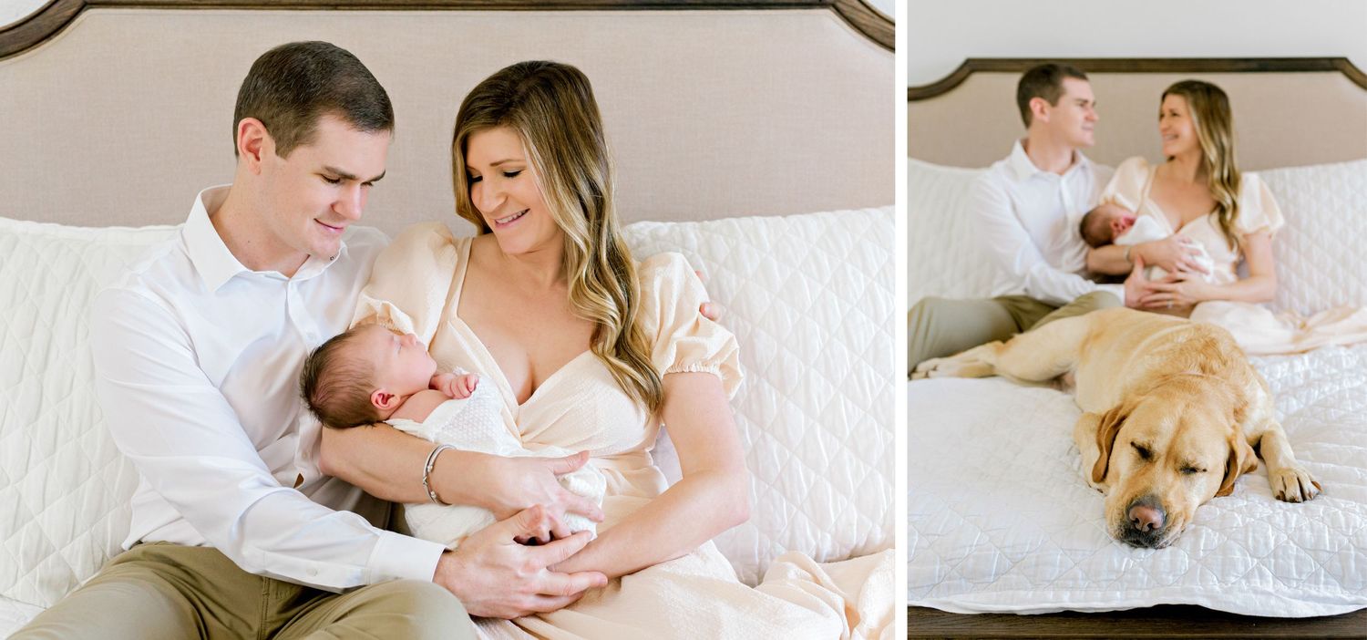 Parents share tender moment with newborn while dog rests on white bed.