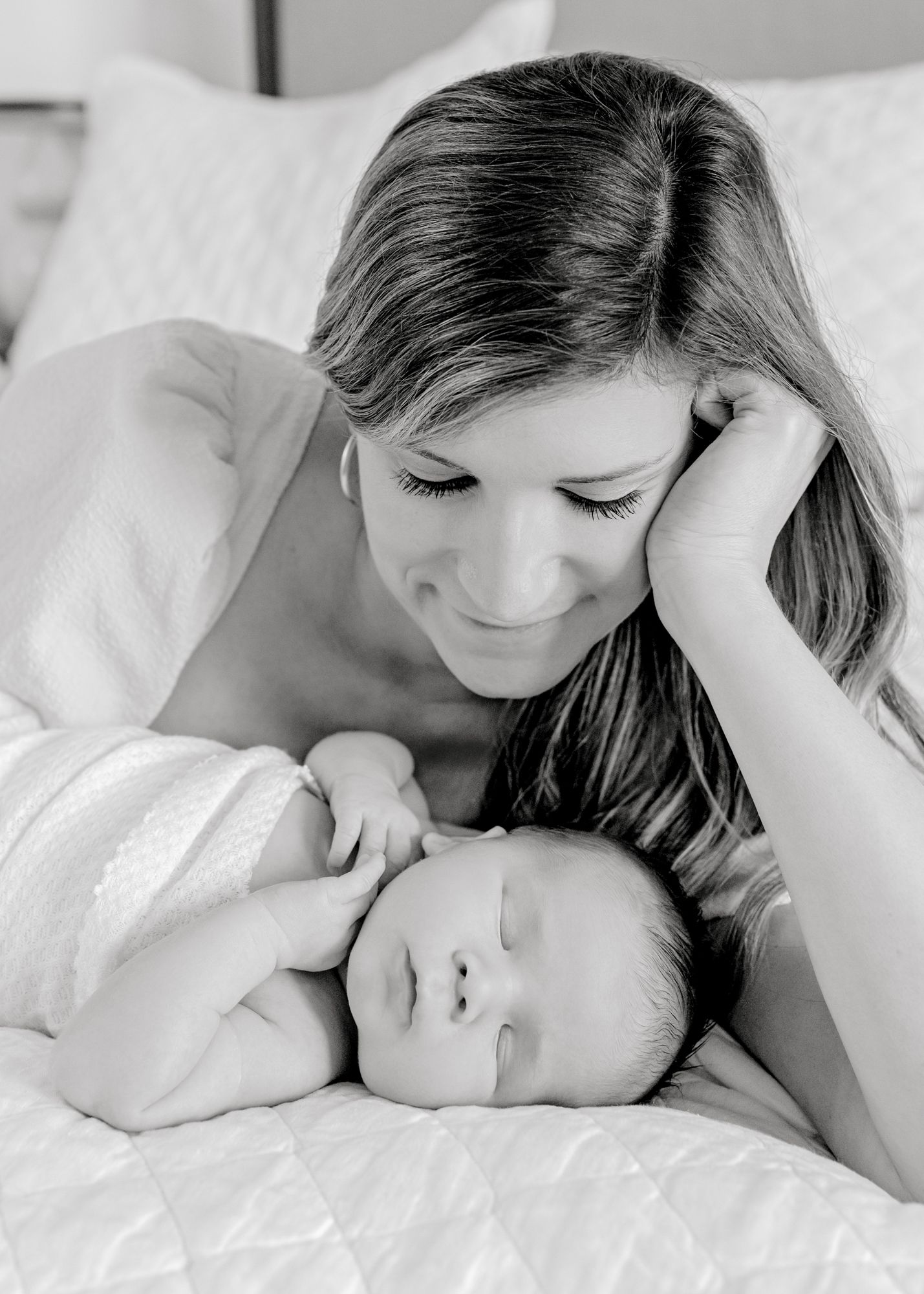 Black and white portrait of tender moment with sleeping newborn.