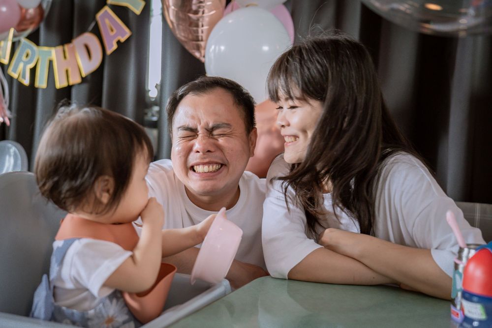 A family sharing joyful laughter together at a celebration table.