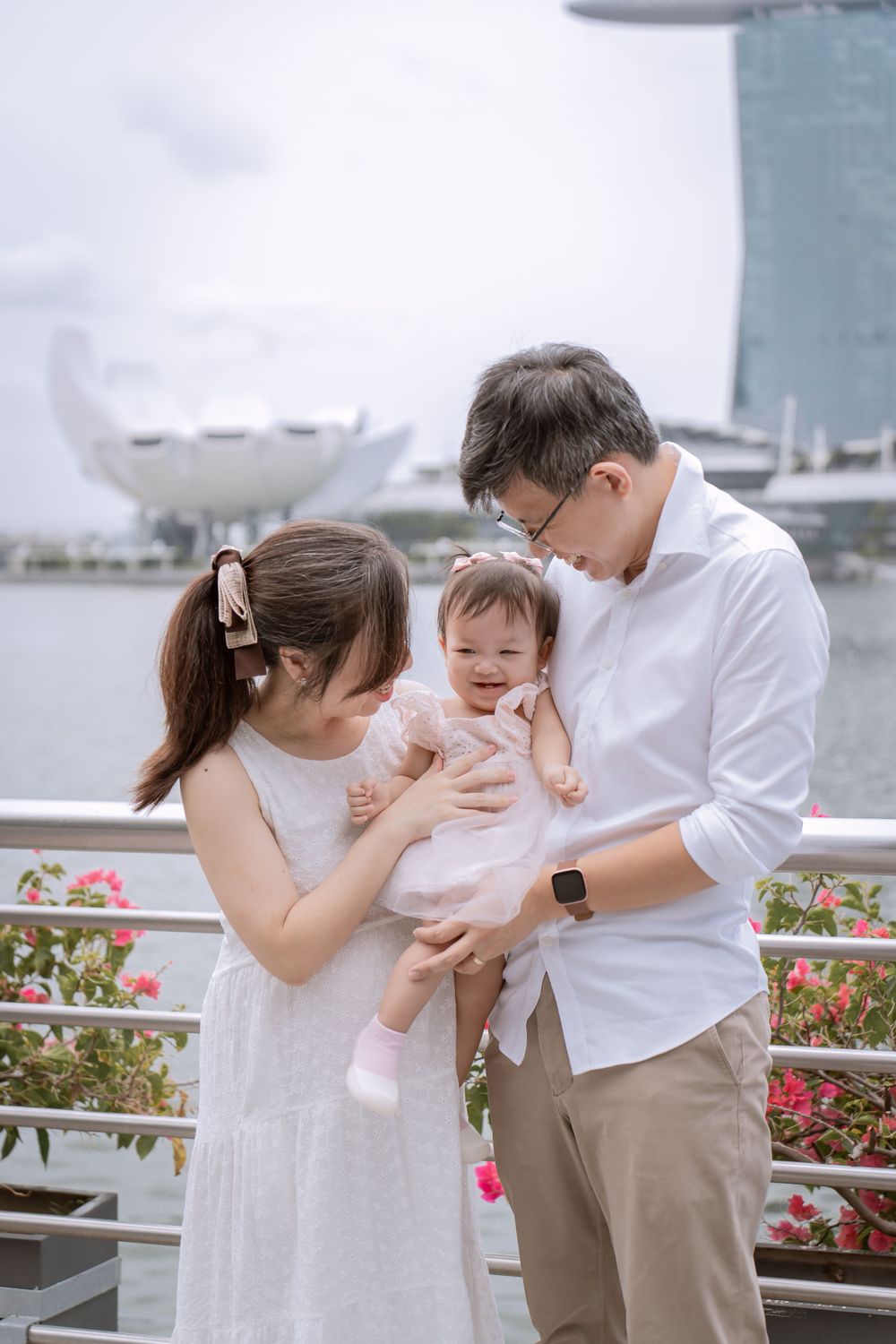 A family sharing tender moment with baby against Singapore skyline.