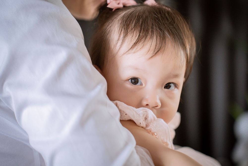 A young child being held and comforted in a tender moment.