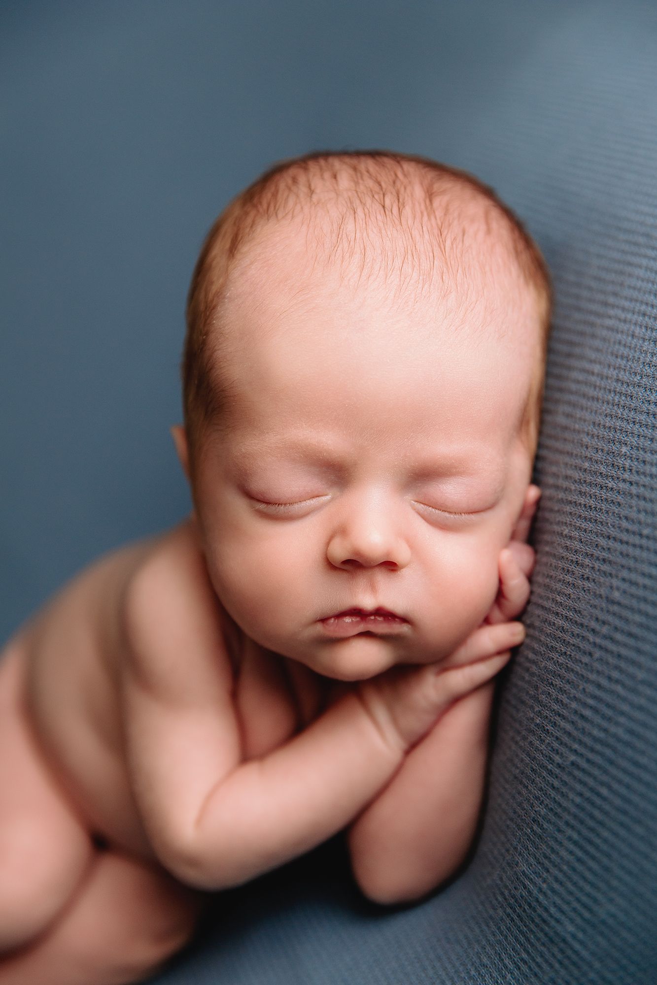 baby boy posed on blue blanket by kansas city studio newborn photographer in 5 star review session