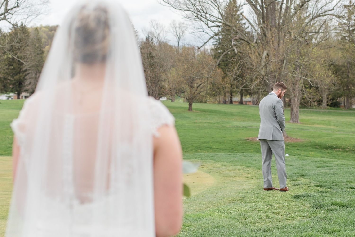 Bride and groom share their first look moment in a scenic outdoor setting.