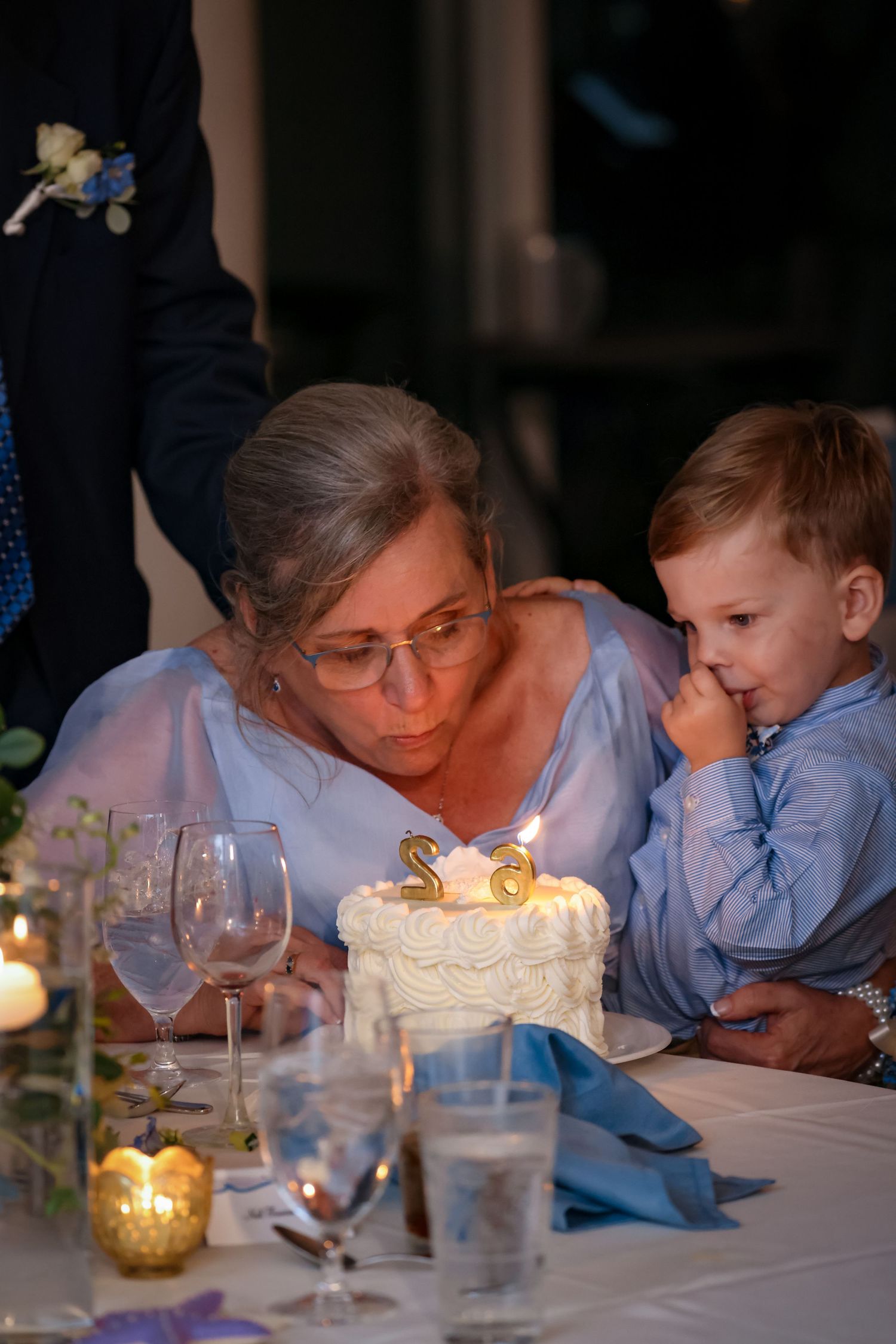 A special moment shared between family members around a birthday cake at a reception table.