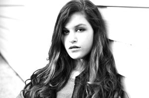 Black and white portrait showing long dark hair and dramatic lighting.