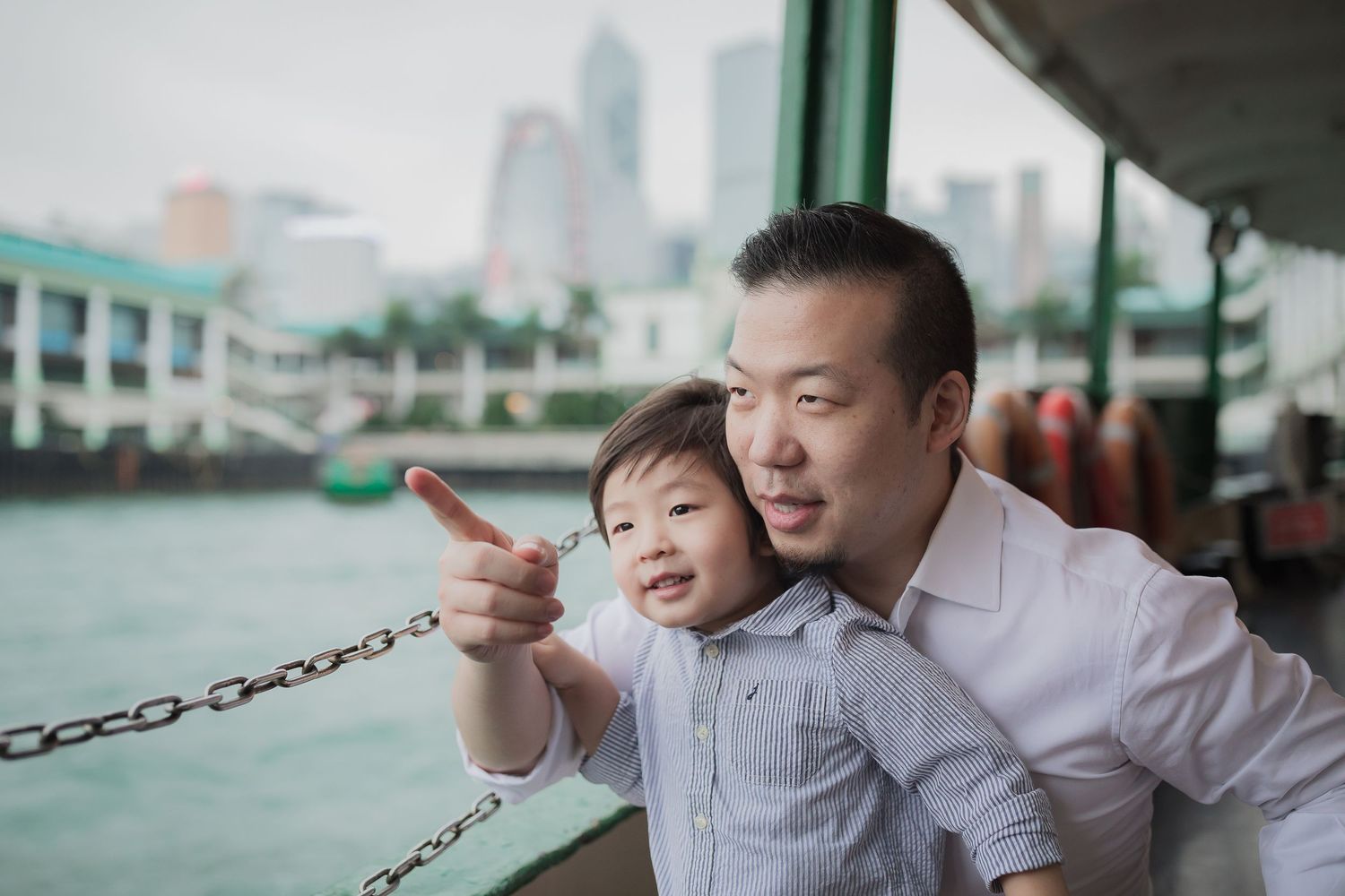 A heartwarming moment overlooking city skyline from ferry or boat deck.