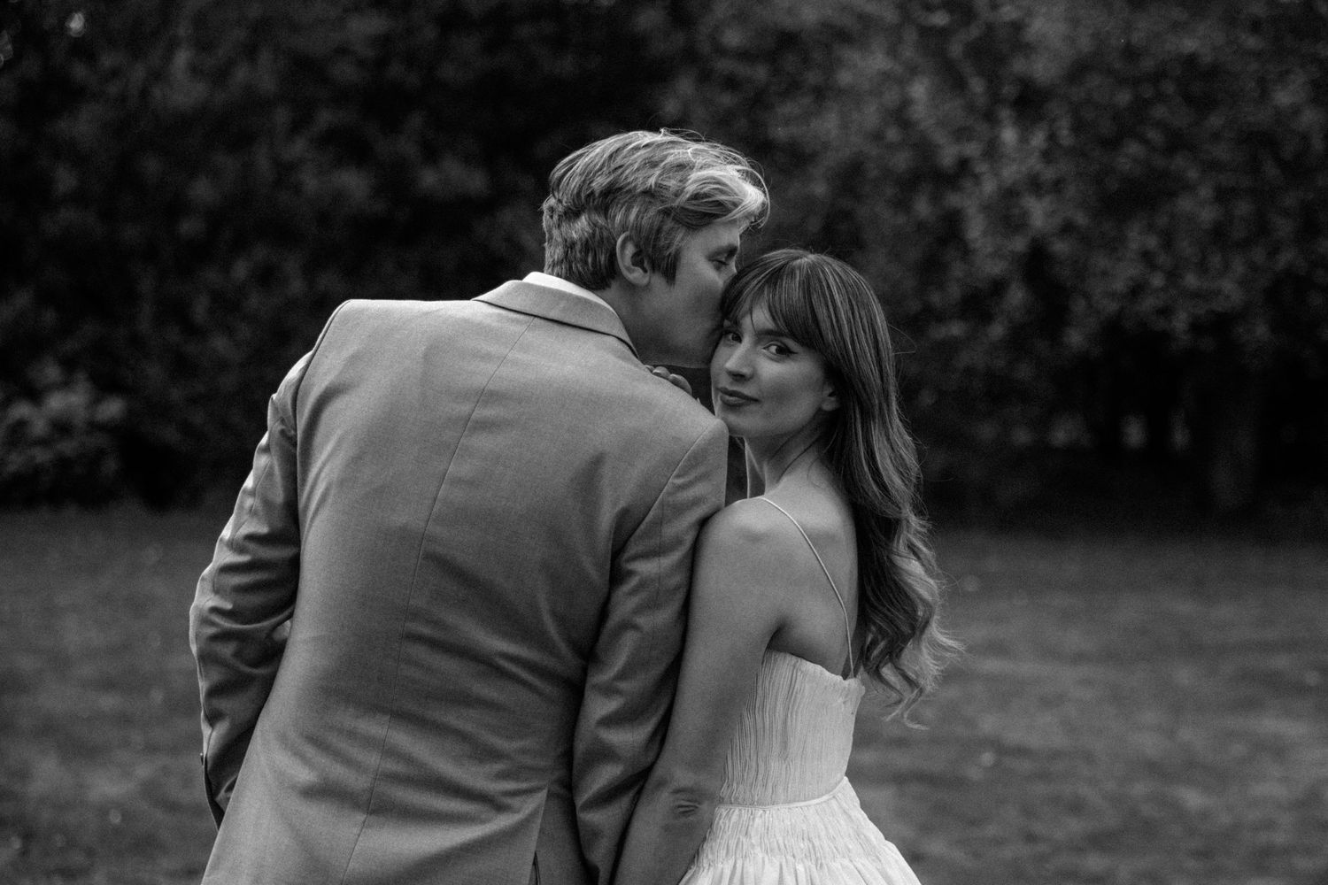 Romantic black and white photo of couple embracing outdoors on their wedding day.