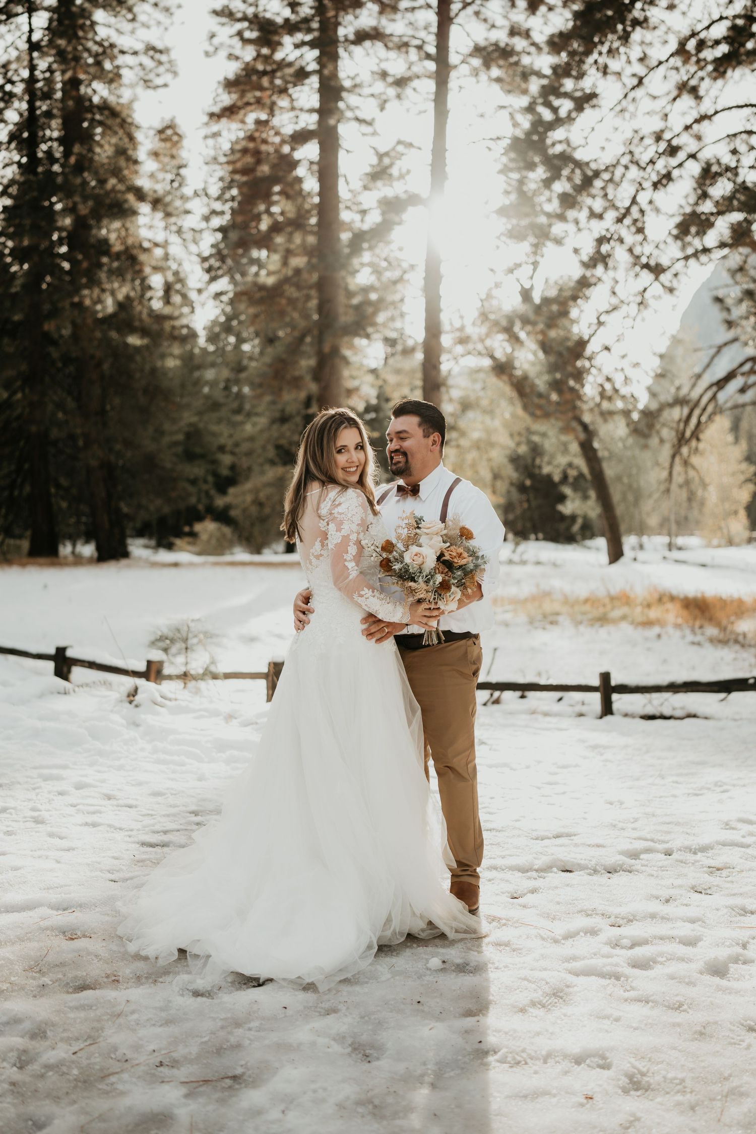 Bride and groom share intimate moment in snow-covered winter forest setting.