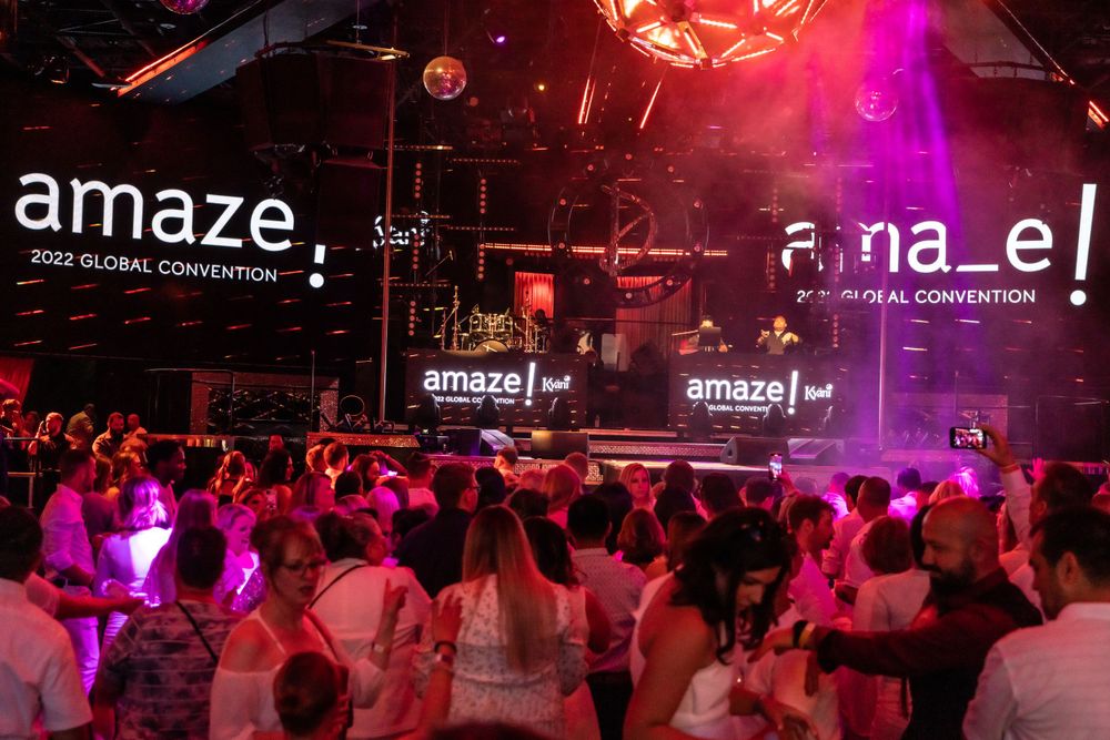 Crowded concert venue with Amaze branding and colorful lighting effects.