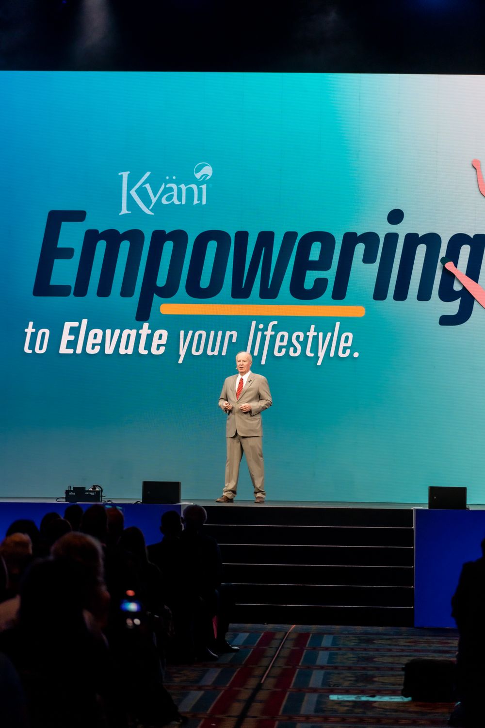 Corporate presentation with Kyani empowerment message on large display screen.