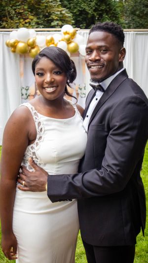 Bride and groom in wedding attire smiling and embracing outdoors.