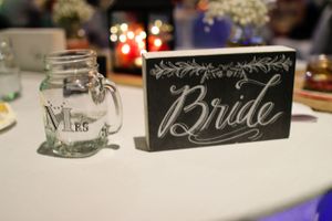 Elegant wedding reception table settings with chalkboard name cards and decorative details.