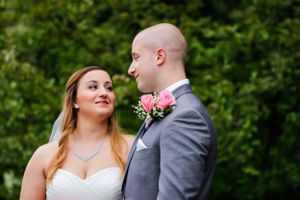 Happy newlyweds share intimate moment during outdoor wedding photography session.