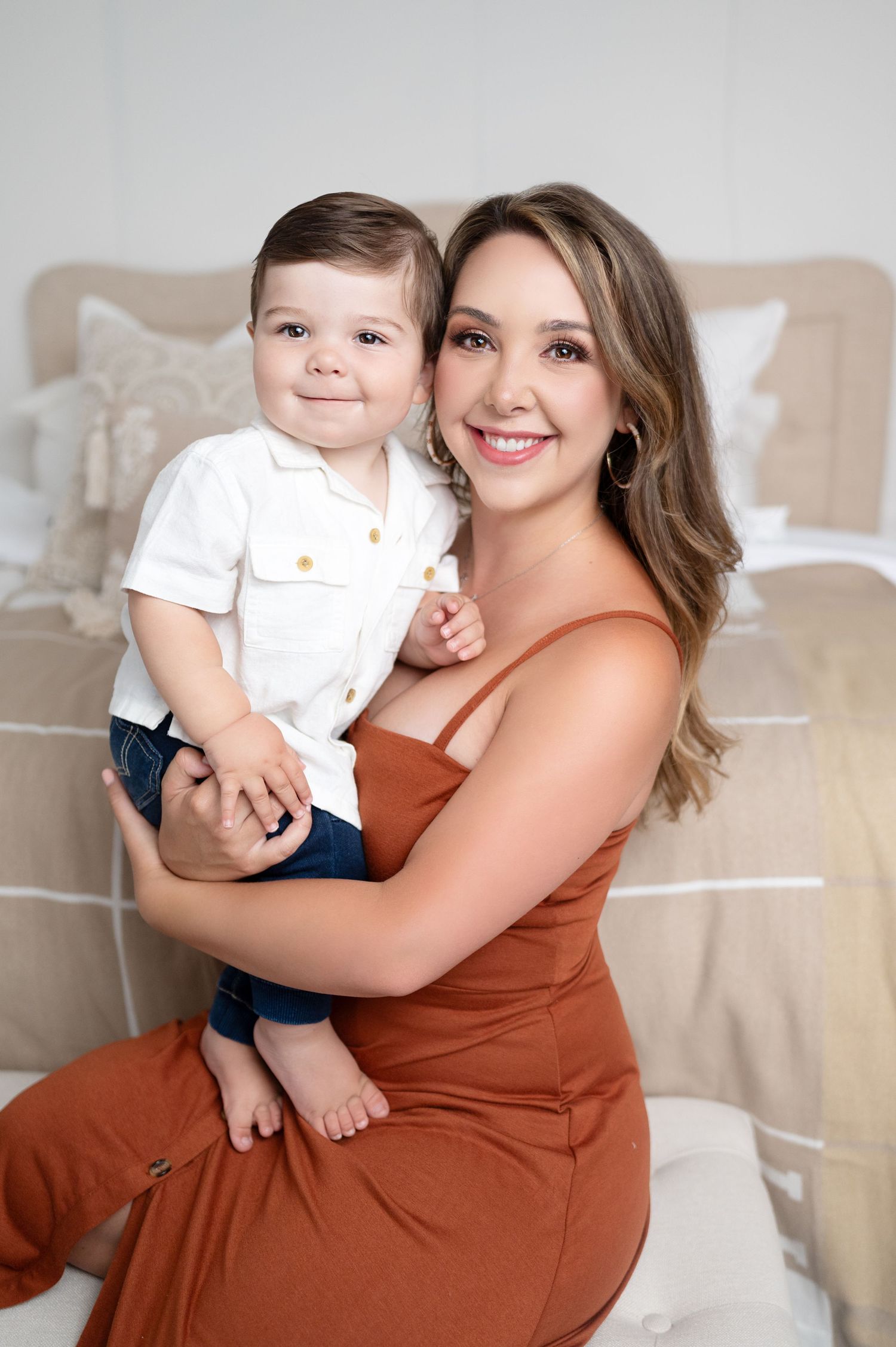 Heartwarming indoor studio portraits of mother and child in warm earth tones.