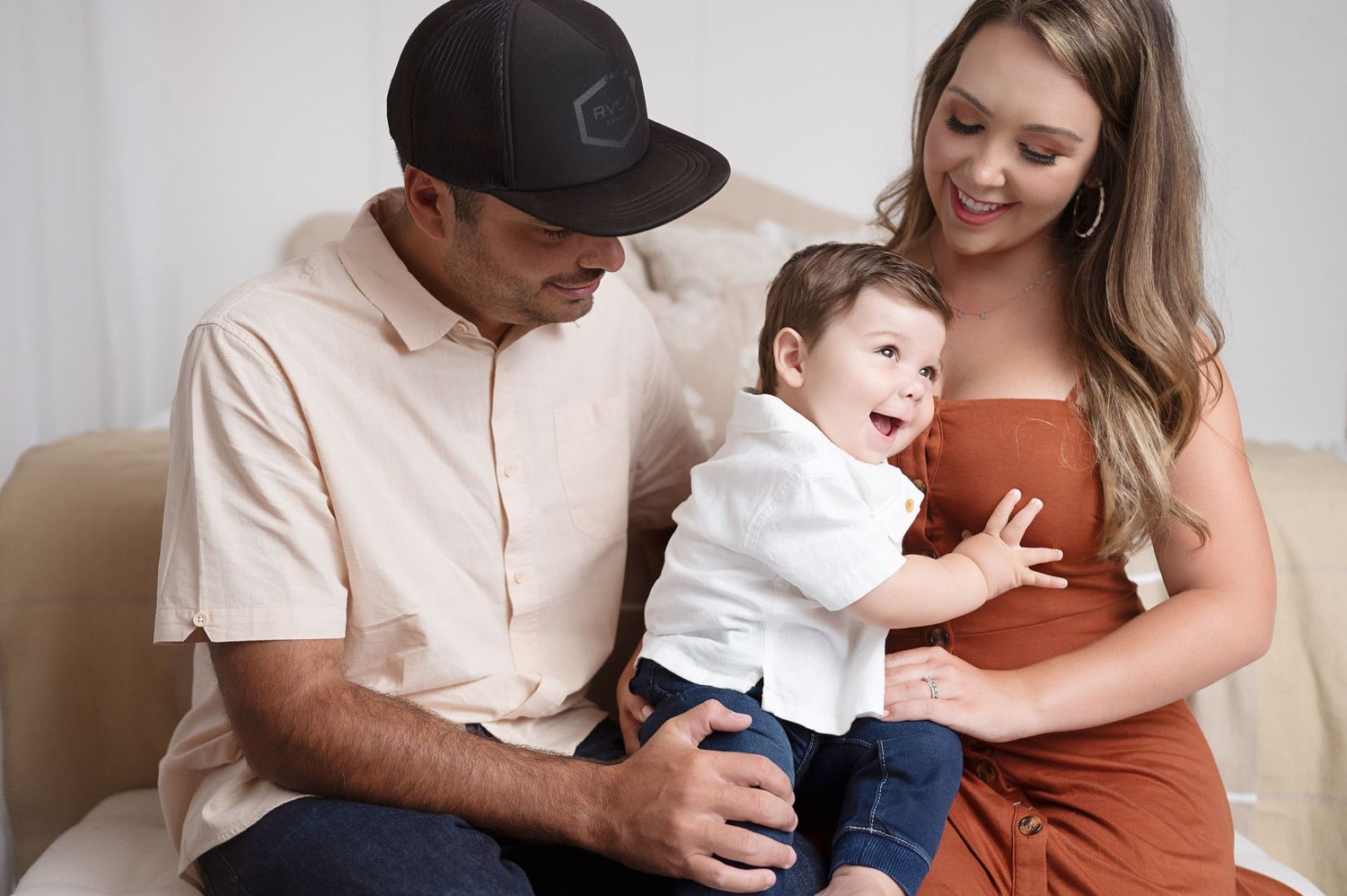 Family portrait session showing tender moments in neutral studio setting.