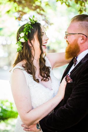 Joyful wedding moment captured in natural light with bride wearing floral crown and lace dress.