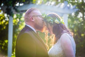 Romantic backlit wedding portrait in golden hour garden setting.