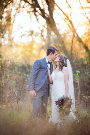 Wedding couple sharing an intimate moment in a golden sunlit field.
