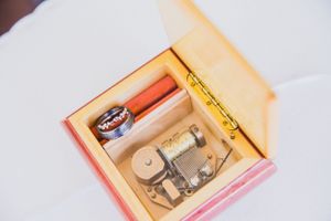 A decorative box containing wedding rings and vintage accessories.