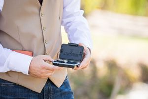 Close-up of someone holding a camera during outdoor wedding photography.