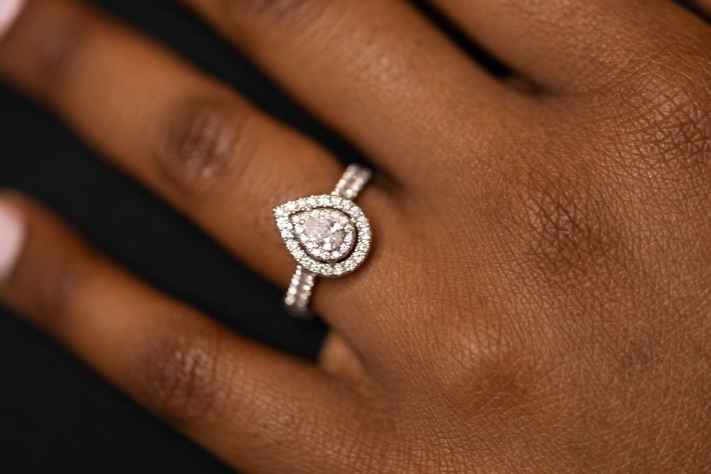 Close-up of a sparkling diamond engagement ring on a hand.