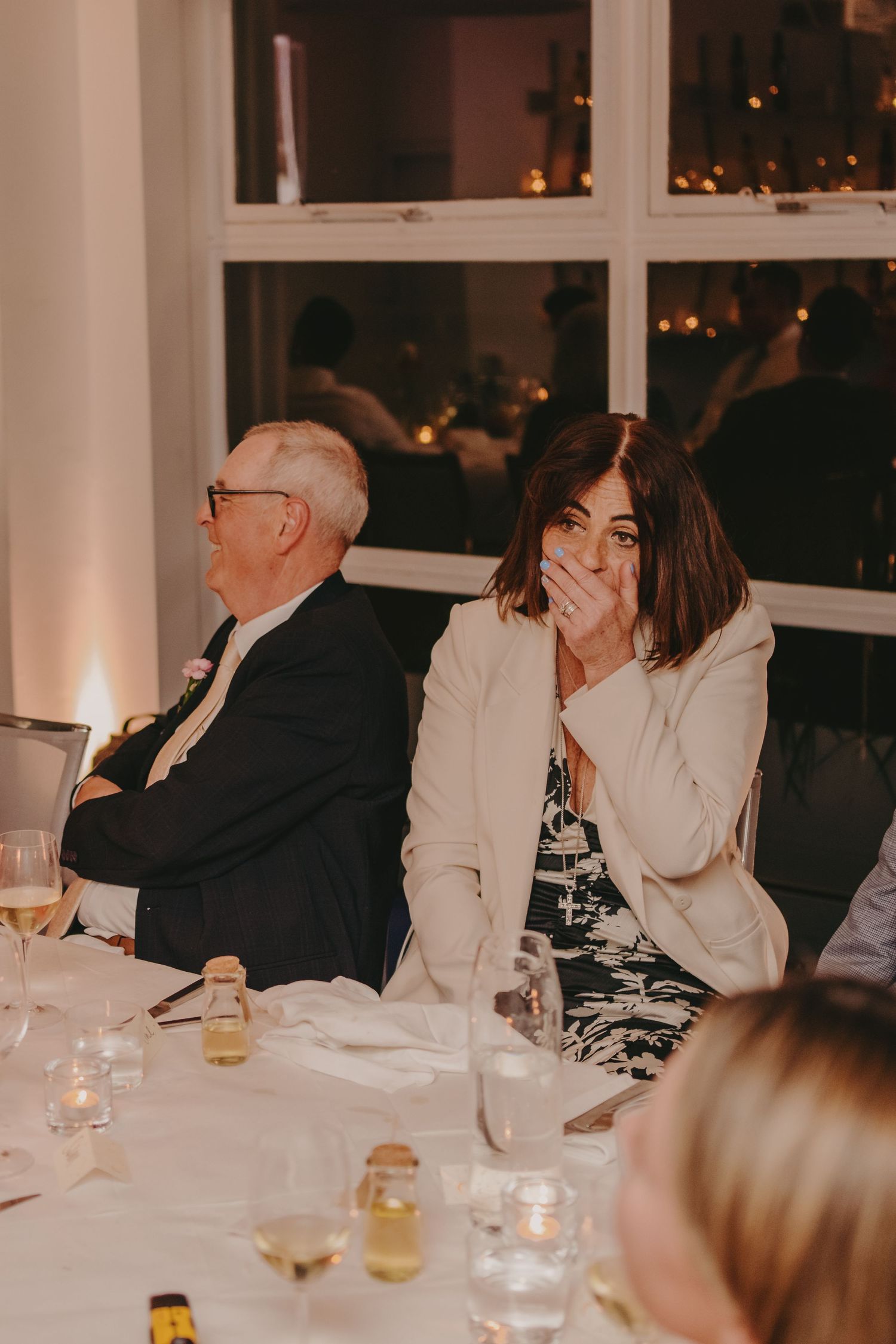 Evening dinner scene with guests reacting emotionally to speeches or toasts.