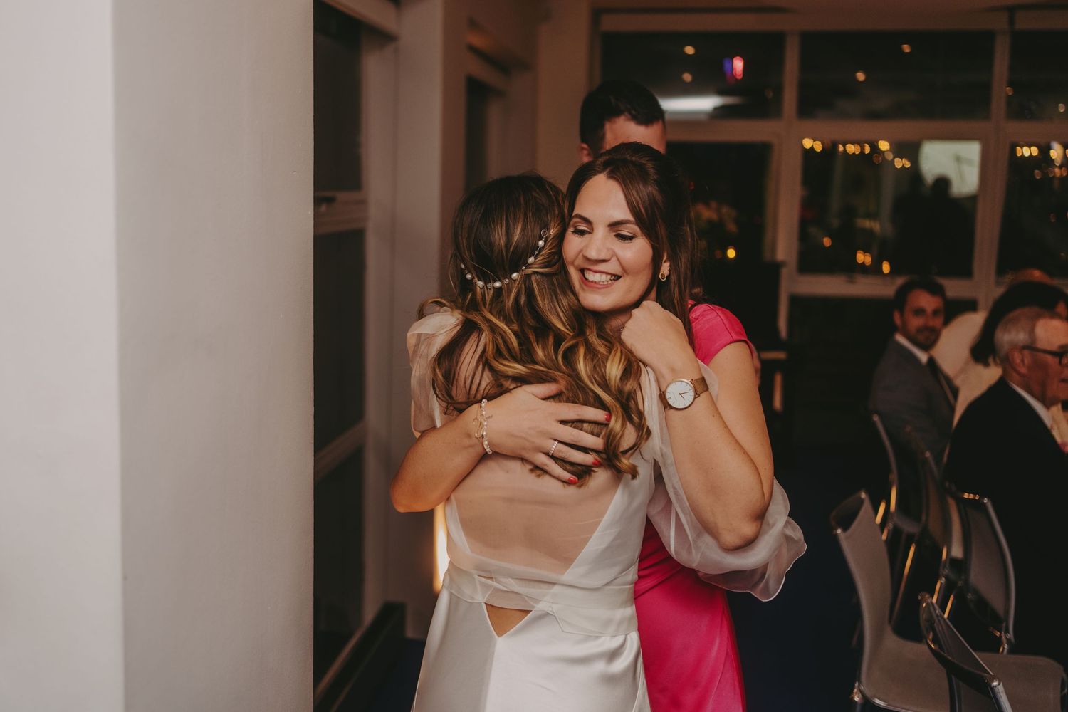 Emotional embrace between guests at a wedding reception.